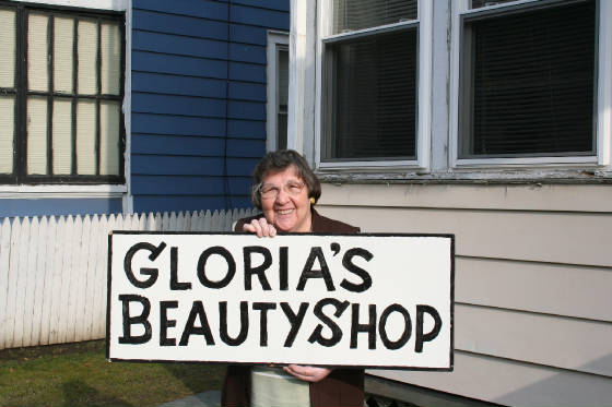 Gloria Marony, with her legendary sign. Photo by Joe Manning, 2013.