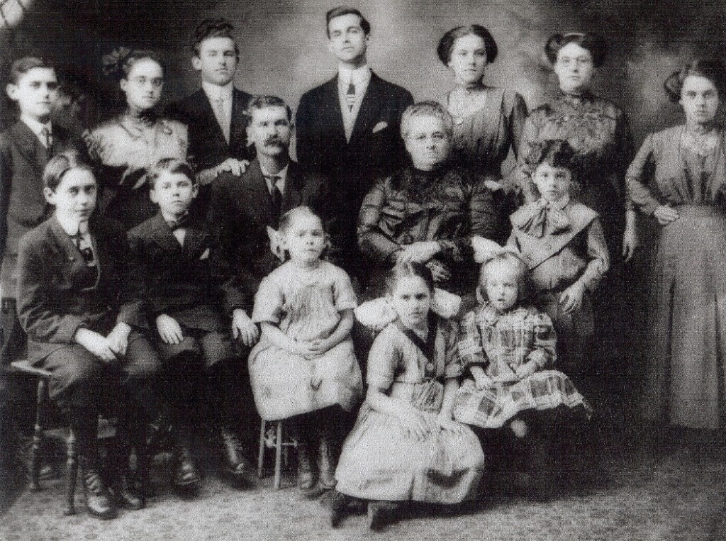 Top row (L-R): Adelard, Alma, Emile, Napoleon, Alexina, Elise, Rosanna. Second row (L-R): Omer, Norbert, Elie (father), Adele (mother), Amedee. Bottom row (L-R): Leocadie, Malvina, Irene.