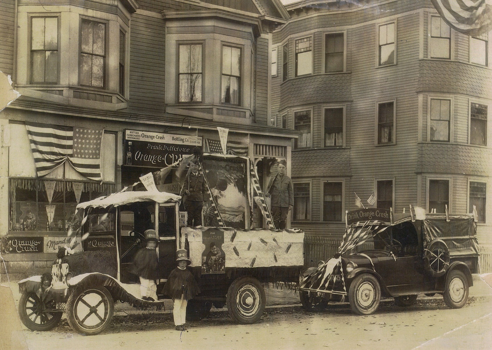 This is a picture of the Valliere home at 114 Farnham Street, where the grocery store and the Orange Crush Bottling Company were located. The date of the picture in not clear, although it was probably in the late 1920s. Mr. Valliere stated that the boy in the truck on the left, and the two small boys in front, were his brothers, although he wasn't sure of each one's identity. On the back of the picture was written, "Bread & Roses parade." 