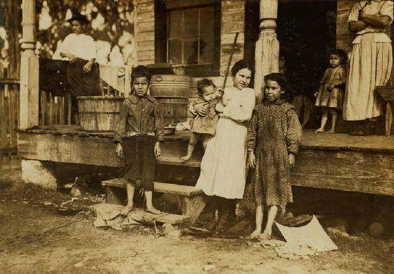 Alma Alves (on porch), with her family, Biloxi, Mississippi, February 1911. Photo by Lewis Hine.